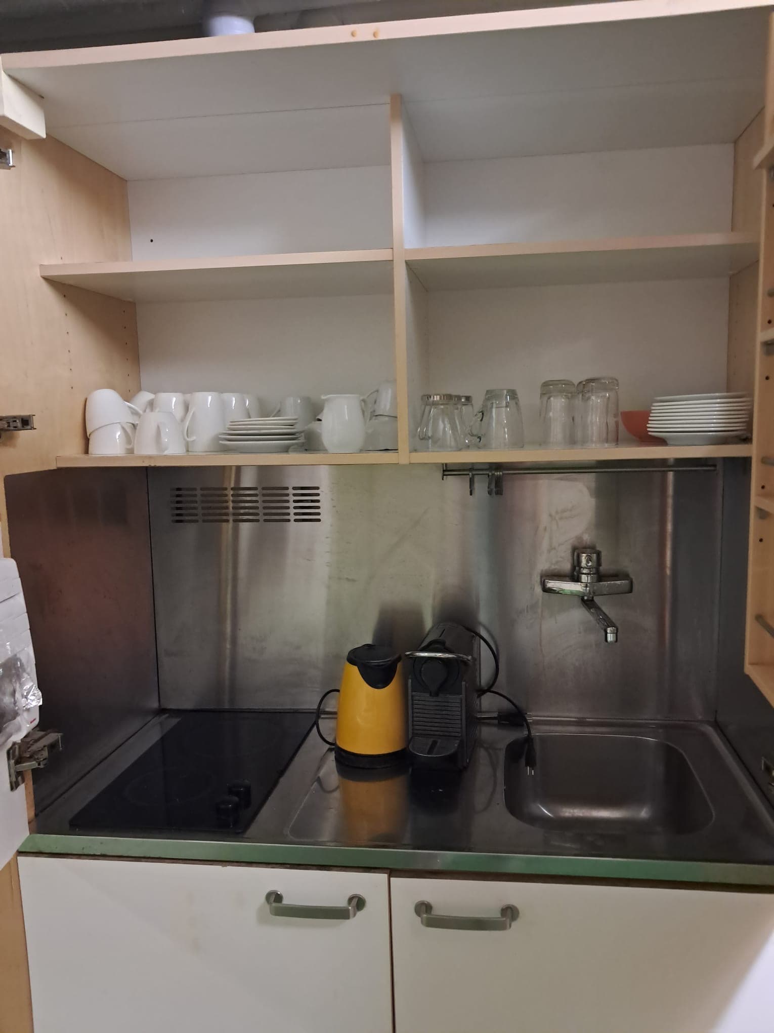Küche im Kaffeeraum mit Kochplatten, Spüle und Geschirr