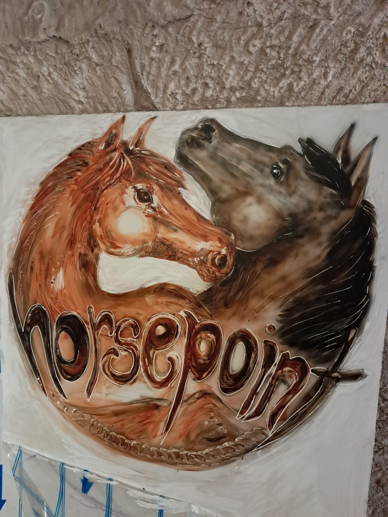 Das handgemalte Horsepoint-Signet mit zwei Pferdeköpfen